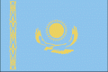 Flagget til Kasaksthan. En gul sol med 32 stråler over en steppeørn på en blå bakgrunn, og med tradisjonelle ornamenter på den ene siden