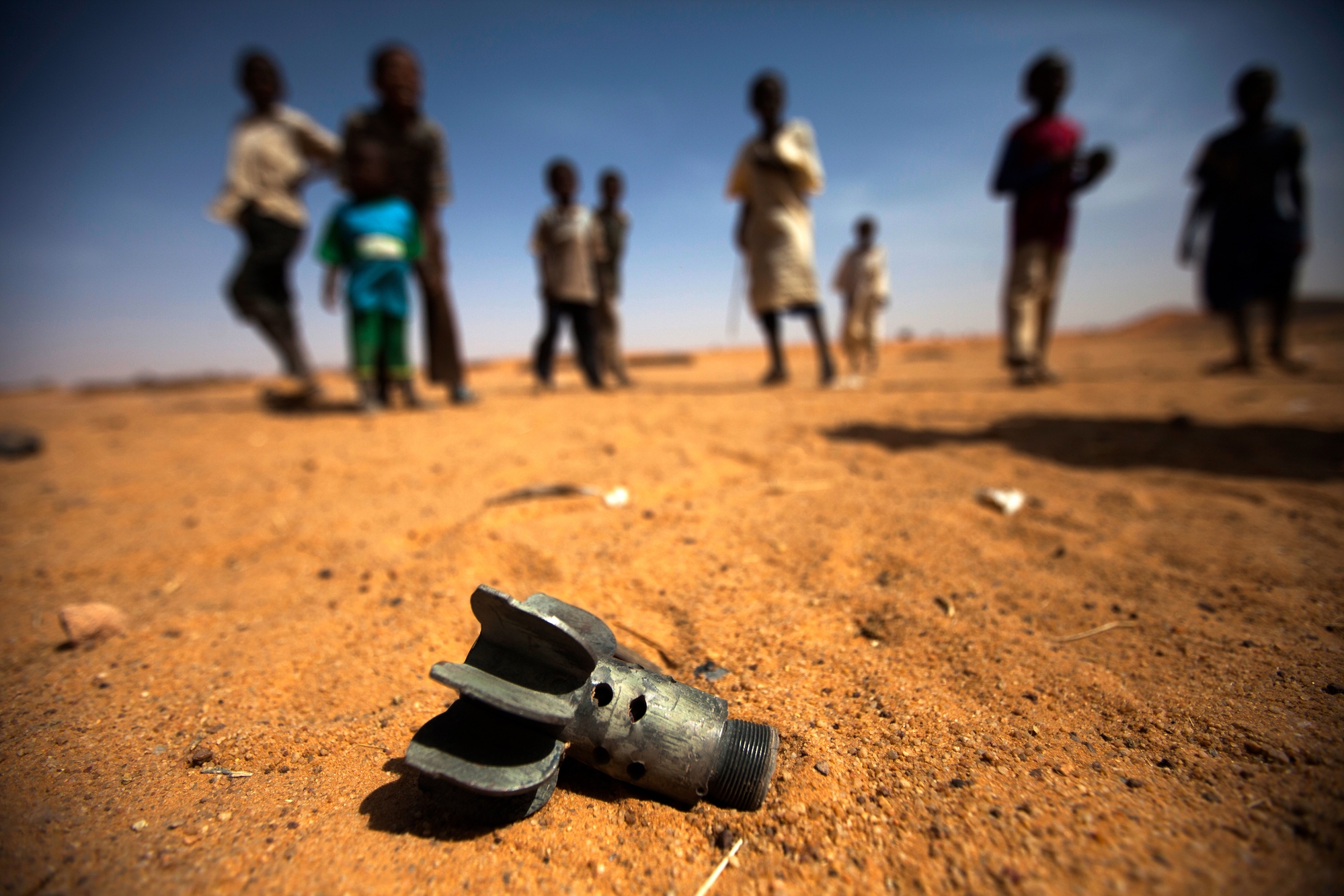 Restene av en bombekaster har havnet i en flyktningeleir i Darfur der barn leker.  Foto: UN Photo/Albert González Farran