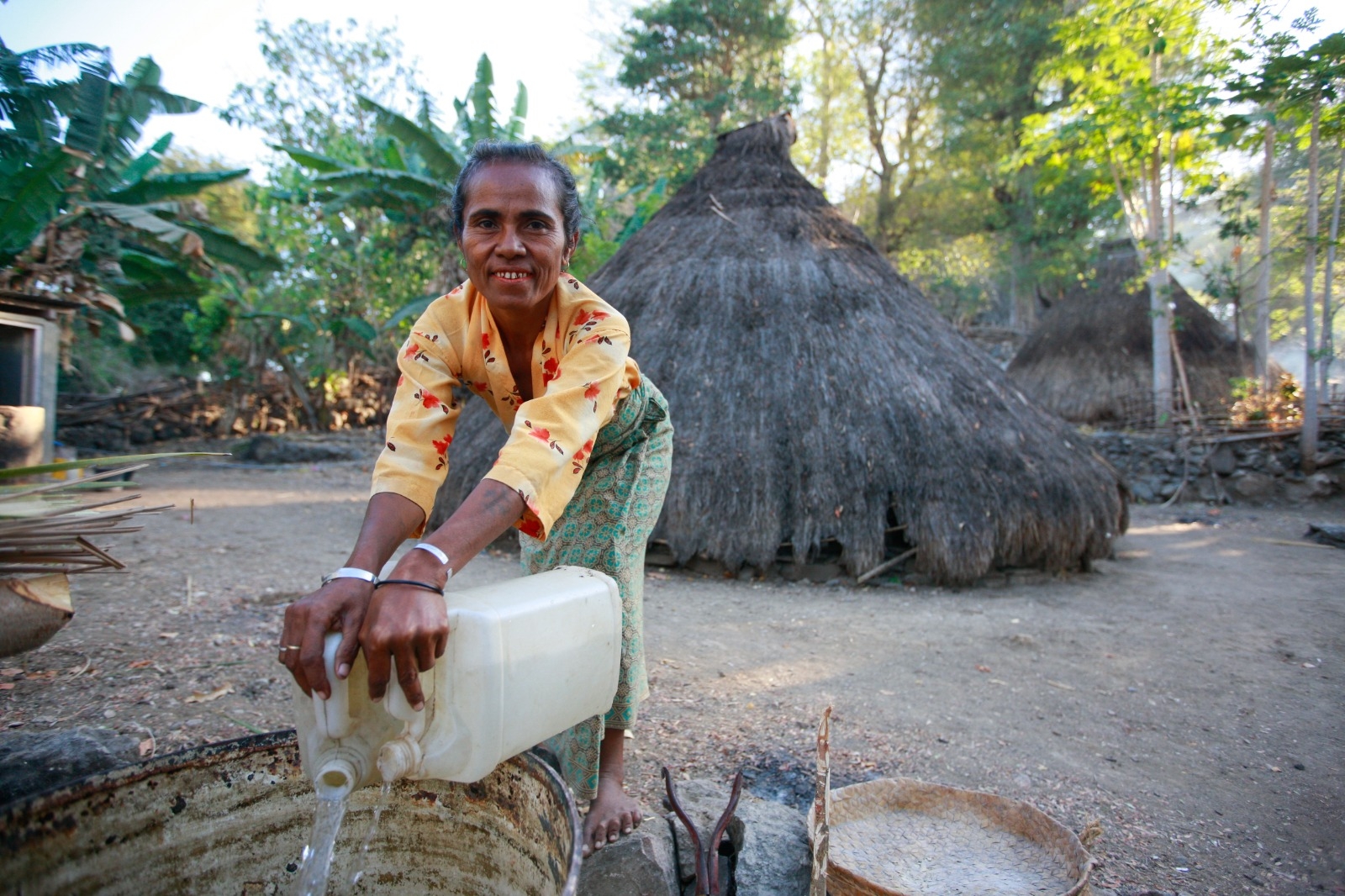 En kvinne henter vann utenfor huset sitt i Øst-Timor. Foto: UN Photo/Martine Perret