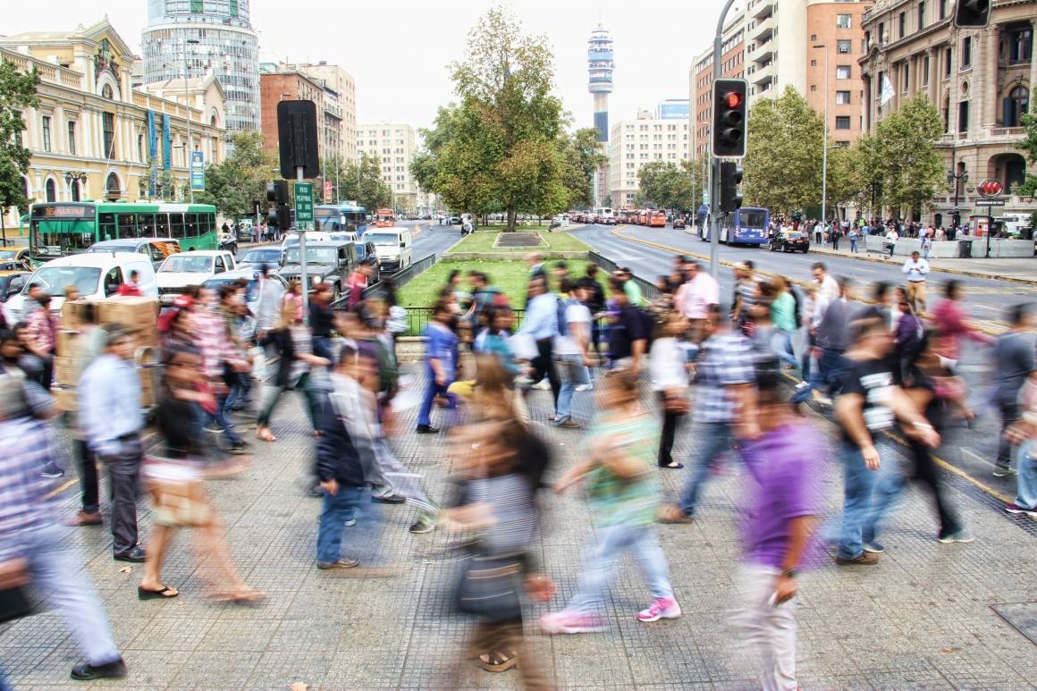 Bildet viser masse mennesker passere over en fotgjengerovergang. Bildet er tatt i Santiago, Chile og er tatt med lang lukkertid så at menneskene ser ut til å bevege seg og er uskarpe.