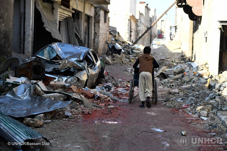 Ung gutt triller rullestol gjennom ruinene i Øst Aleppo.