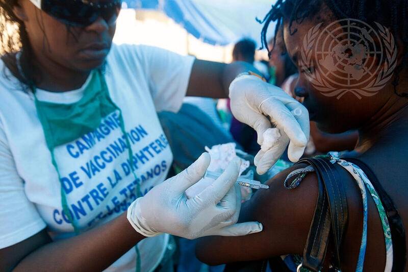 En helsearbeider i regi av Verdens helseorganisasjon (WHO) administrer vaksine mot difteri og stivkrampe til haitiere som har blitt fordrevet som følge av jordskjelvet i 2010. Foto: UNPHOTO//UN7400011