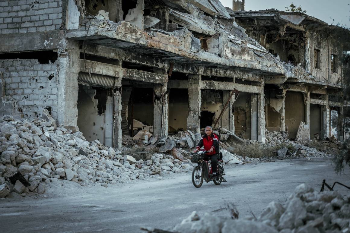 En mann kjører gjennom ødelagte gater i Syria på sykkelen sin. Krigen i landet har også svekket landets beredskap mot naturkatastrofer. Foto: Unsplash/ Mahmoud Sulaiman l