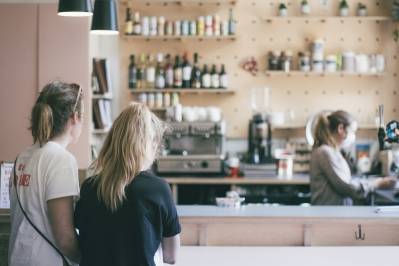 To kvinner venter på kaffe ved disken på en kafe.